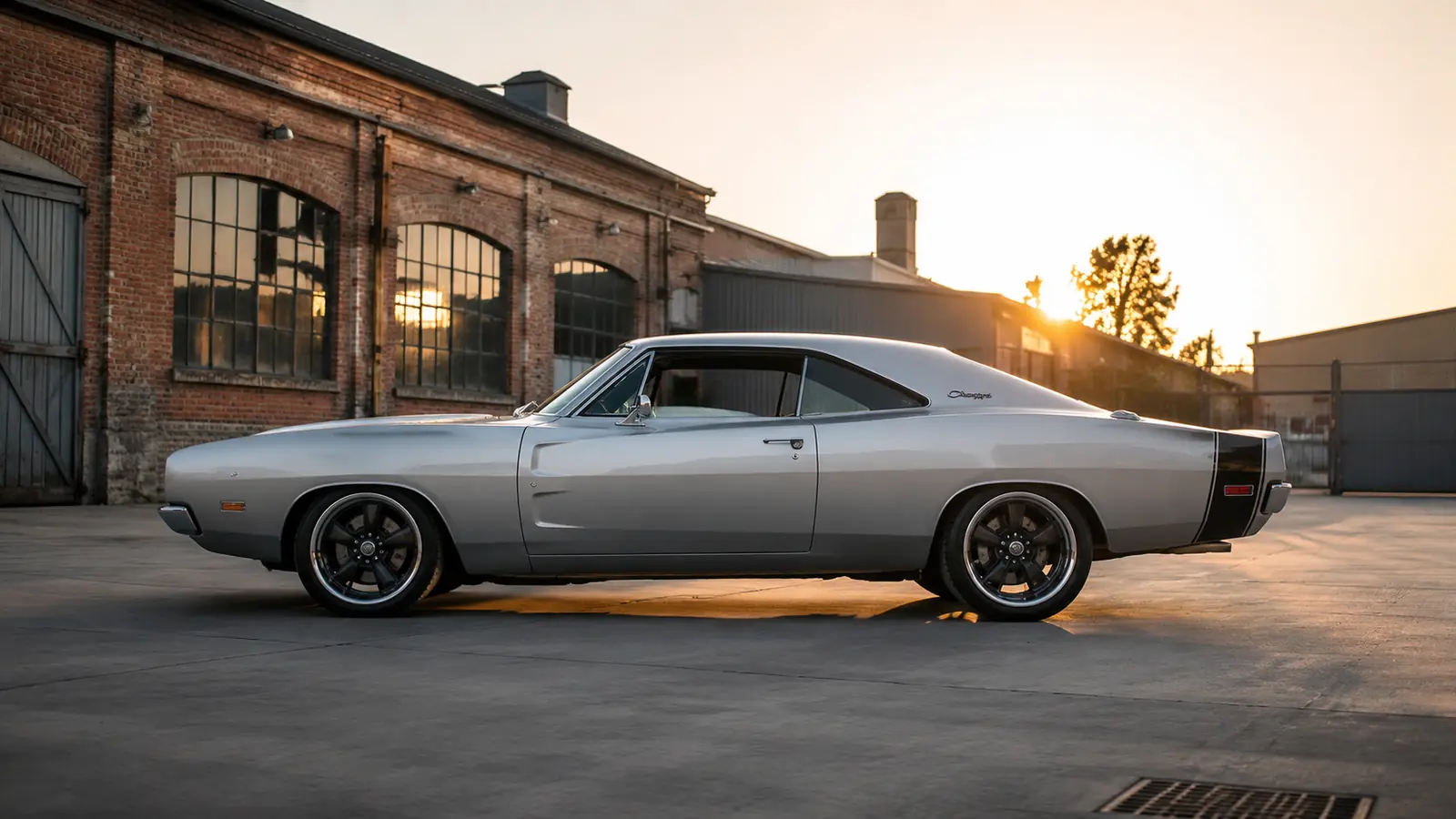 АВТО 1002784 серебристый Dodge Charger 1969 крупно в индустриальном дворе на закате