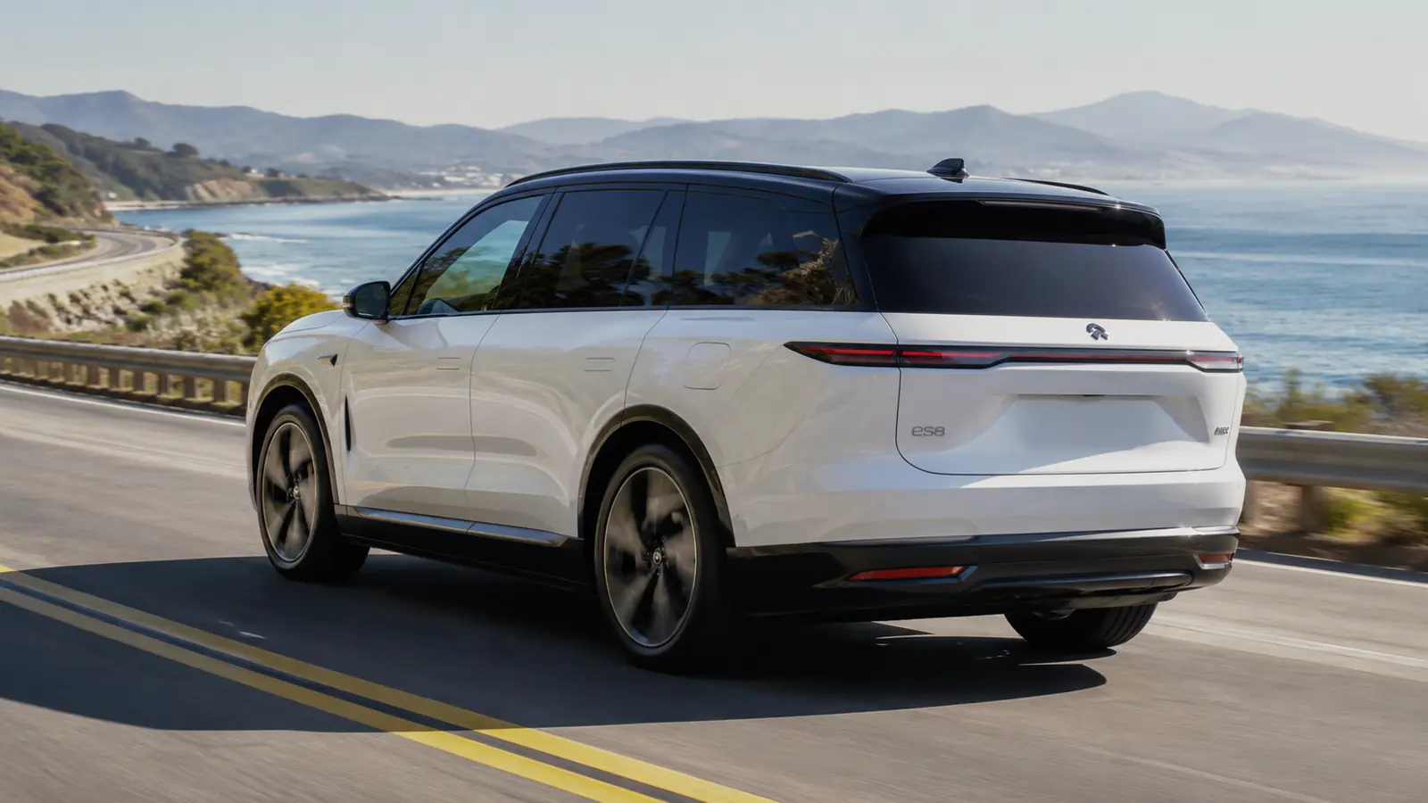 АВТО 1002710 белый NIO ES8 крупно на дороге у океана
