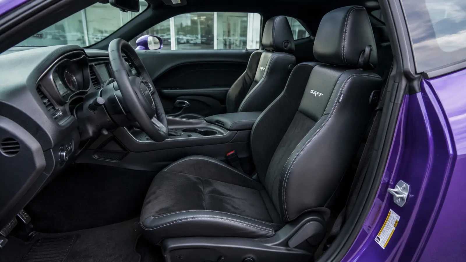 АВТО 1003021 фиолетовый Dodge Challenger SRT передние кресла и центральная консоль крупным планом у минималистичного шоурума