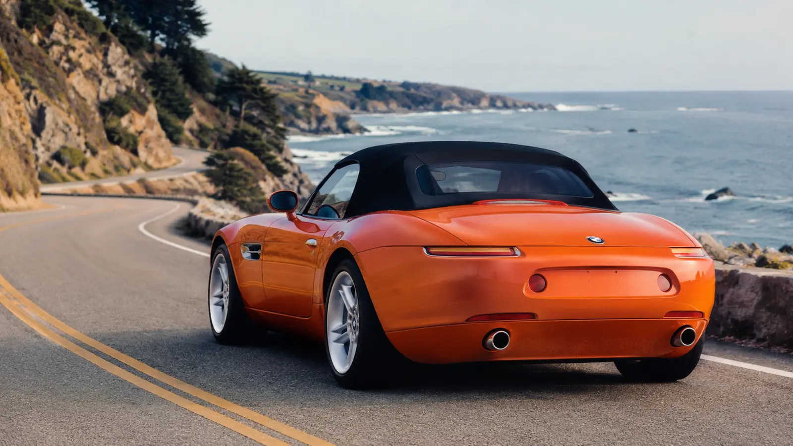 АВТО 1000864 оранжевый BMW Z8 на прибрежной дороге 2000-х