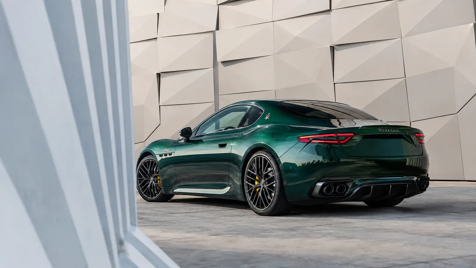 АВТО 1002778 зелёный Maserati GranTurismo Trofeo крупно у геометричного фасада