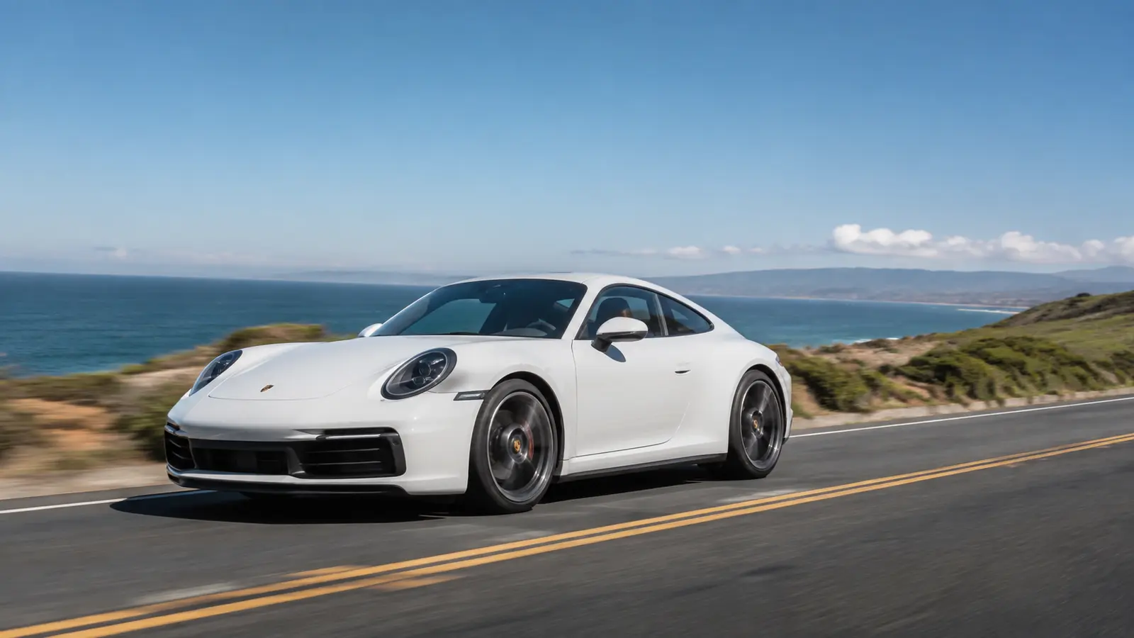 АВТО 1000656 белый Porsche 911 в движении вдоль побережья