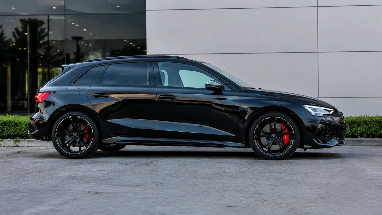 АВТО 1002686 чёрный Audi RS3 крупно у минималистичного шоурума