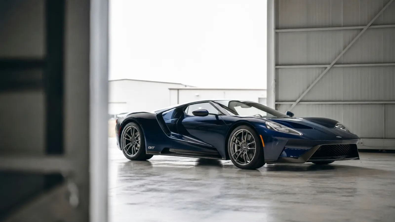 АВТО 1003318 тёмно-синий Ford GT крупно через мягкий передний план