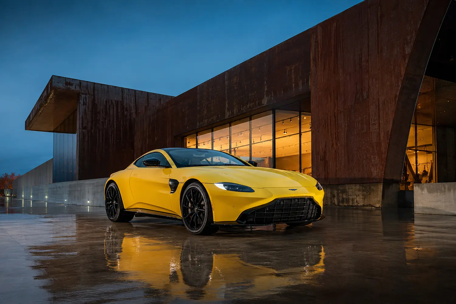 АВТО 1003672 жёлтый Aston Martin Vantage у музея из стекла и стали