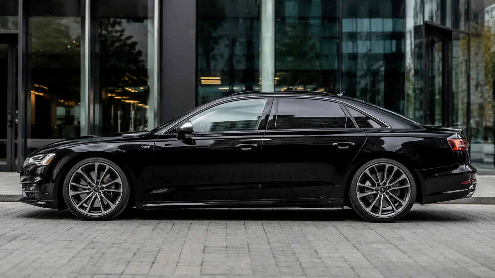 АВТО 1002897 чёрный Audi S8 крупным профилем у делового центра