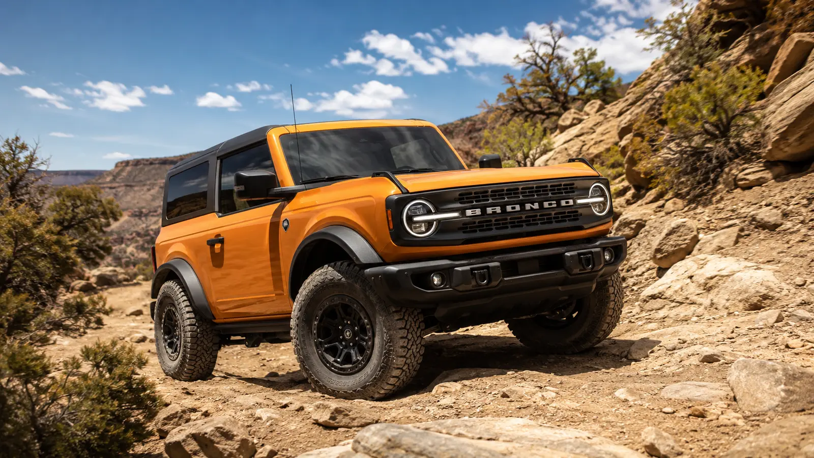 АВТО 1000593 оранжевый Ford Bronco на каменистой дороге