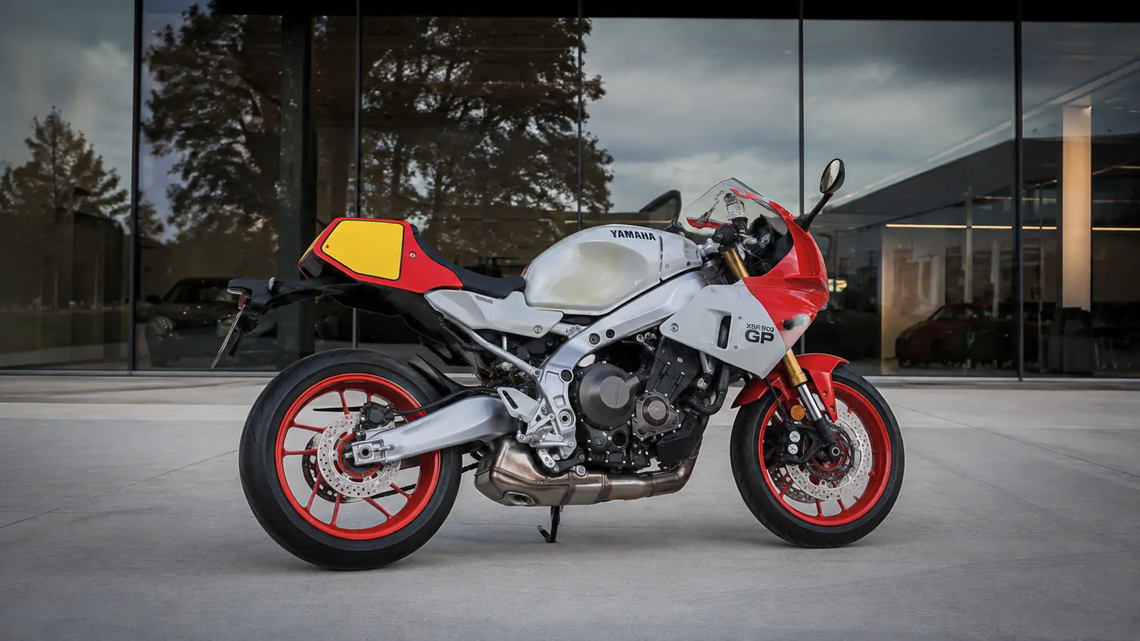 АВТО 1002774 серебристо-красный Yamaha XSR900 GP крупно у минималистичного шоурума
