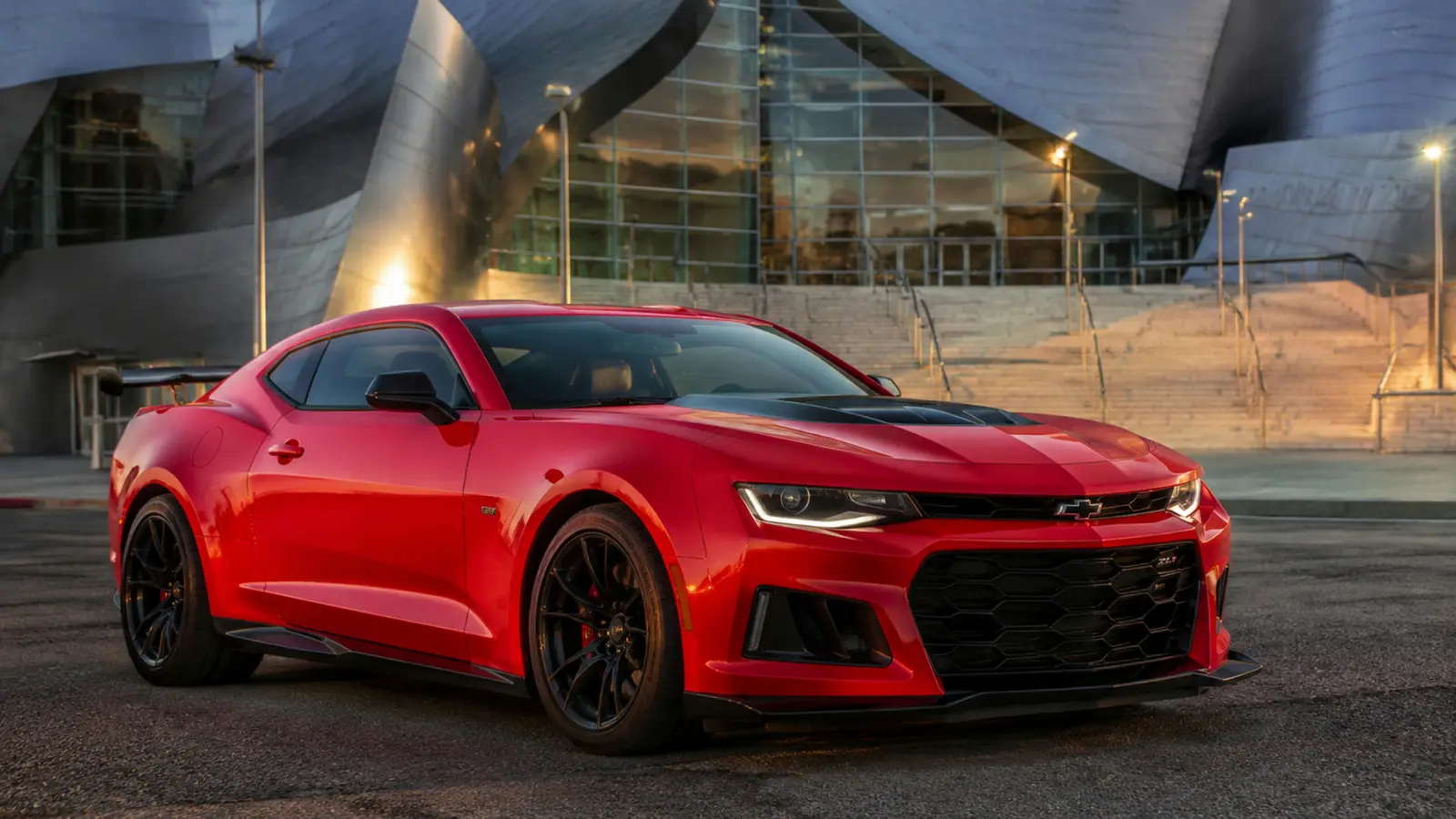 АВТО 1003050 красный Chevrolet Camaro ZL1 крупно общий ракурс с выразительной архитектурой у концертного центра