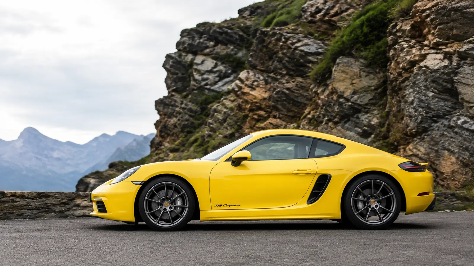 АВТО 1000618 жёлтый Porsche Cayman в профиль у скал