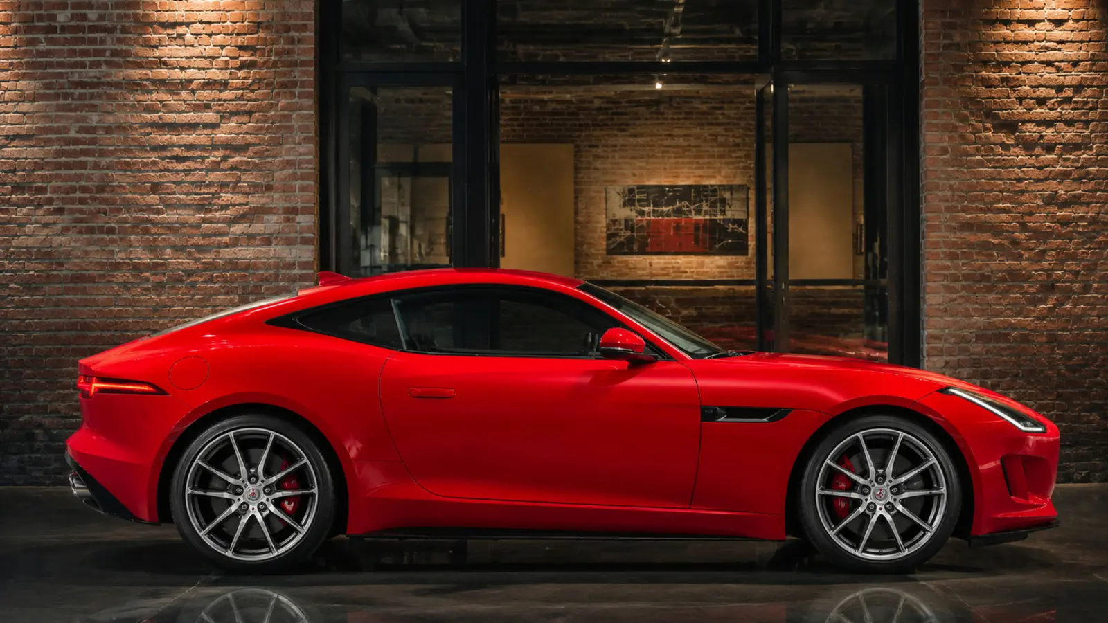 АВТО 1002855 красный Jaguar F Type крупным профилем у кирпичной галереи
