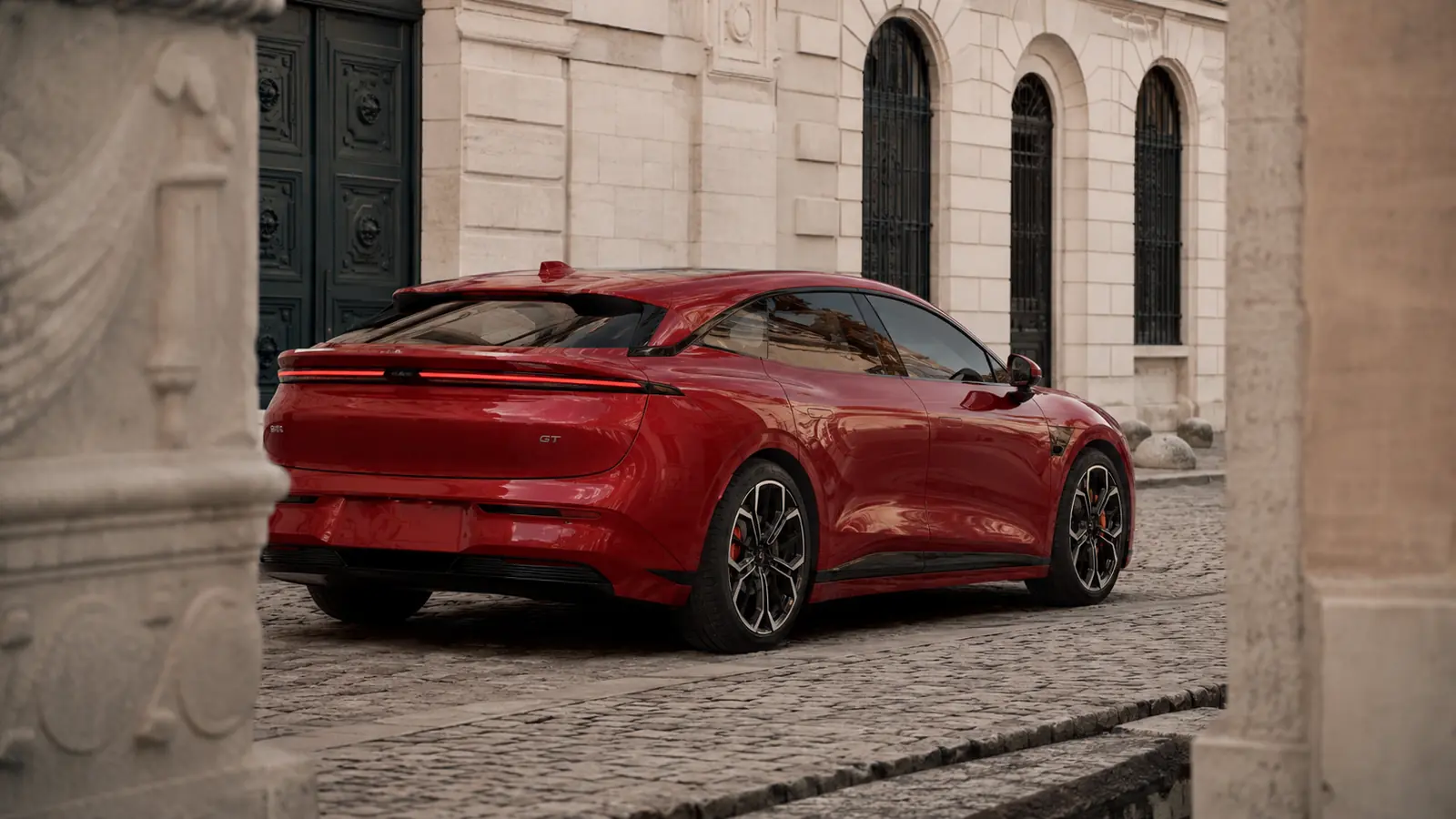 АВТО 1002655 красный Zeekr 007 GT крупно в старом европейском квартале