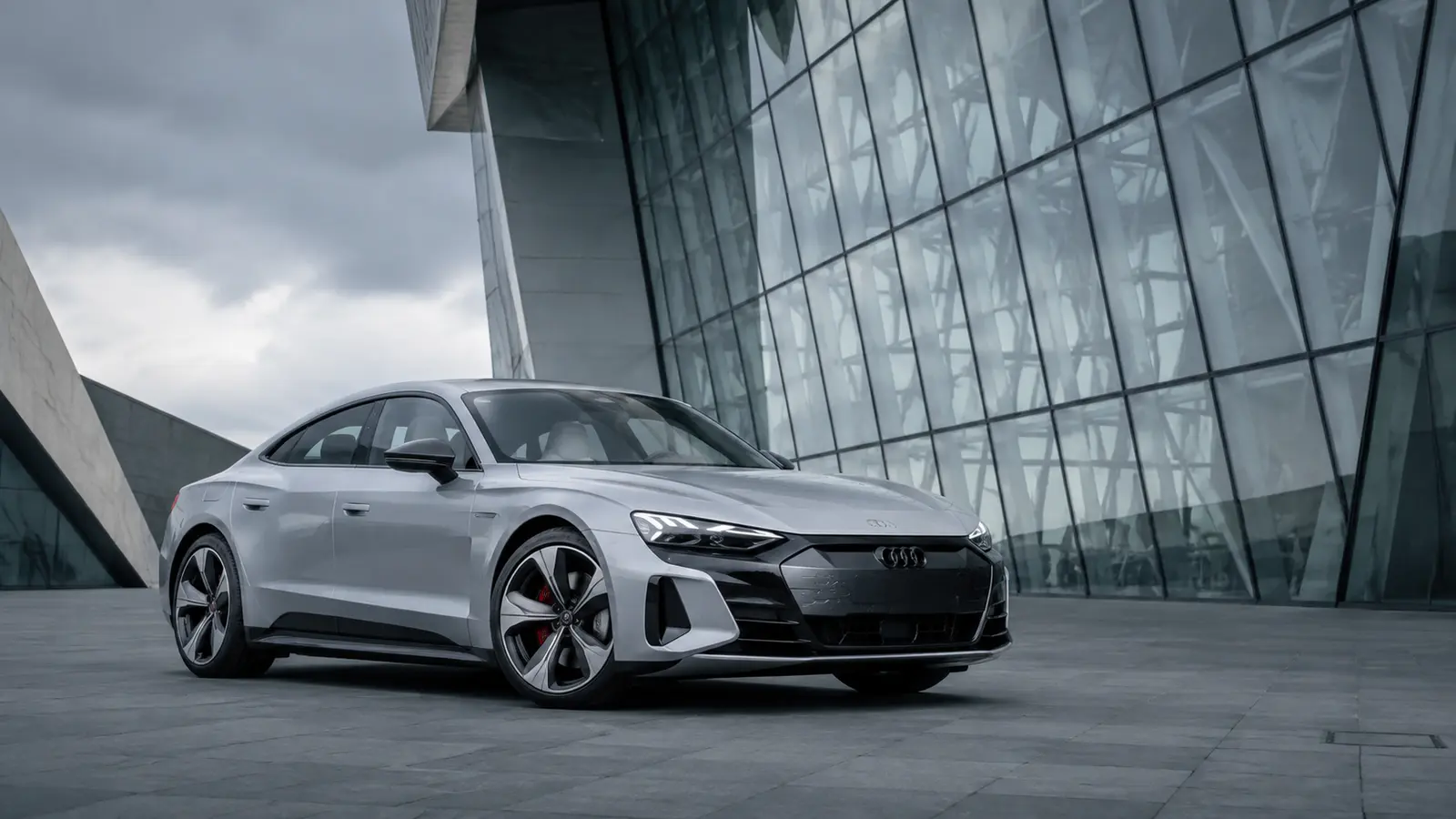 АВТО 1001629 серебристый Audi e-tron GT у стеклянного музея