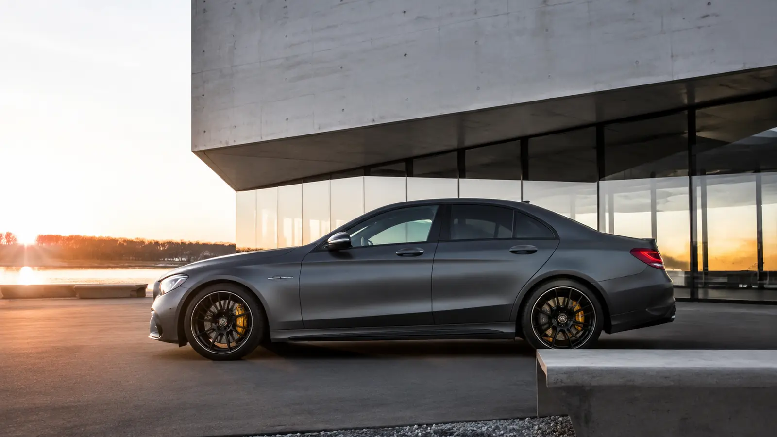 АВТО 1000689 матовый серый Mercedes C63 AMG в профиль у современного музея