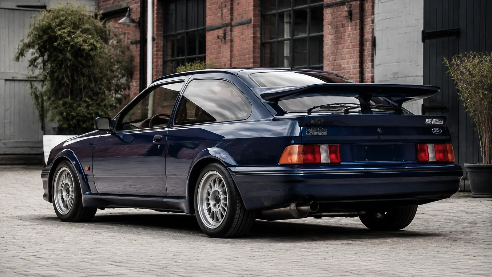 АВТО 1002301 синий Ford Sierra Cosworth крупно в индустриальном дворе