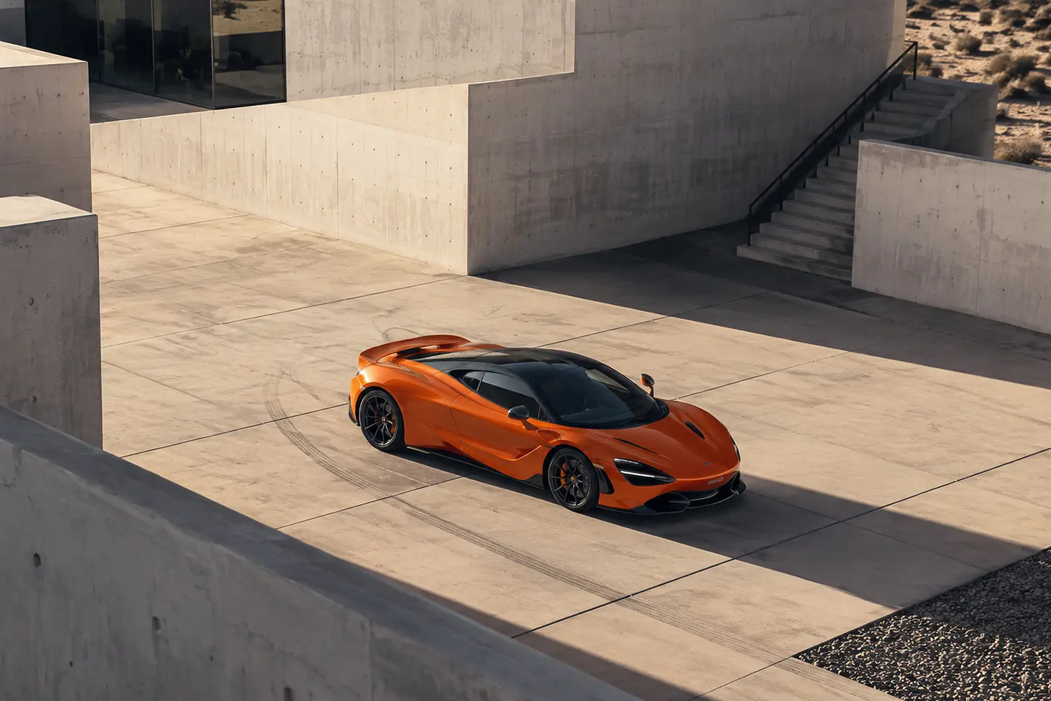 АВТО 1003420 оранжевый McLaren 765LT среди бетонной архитектуры