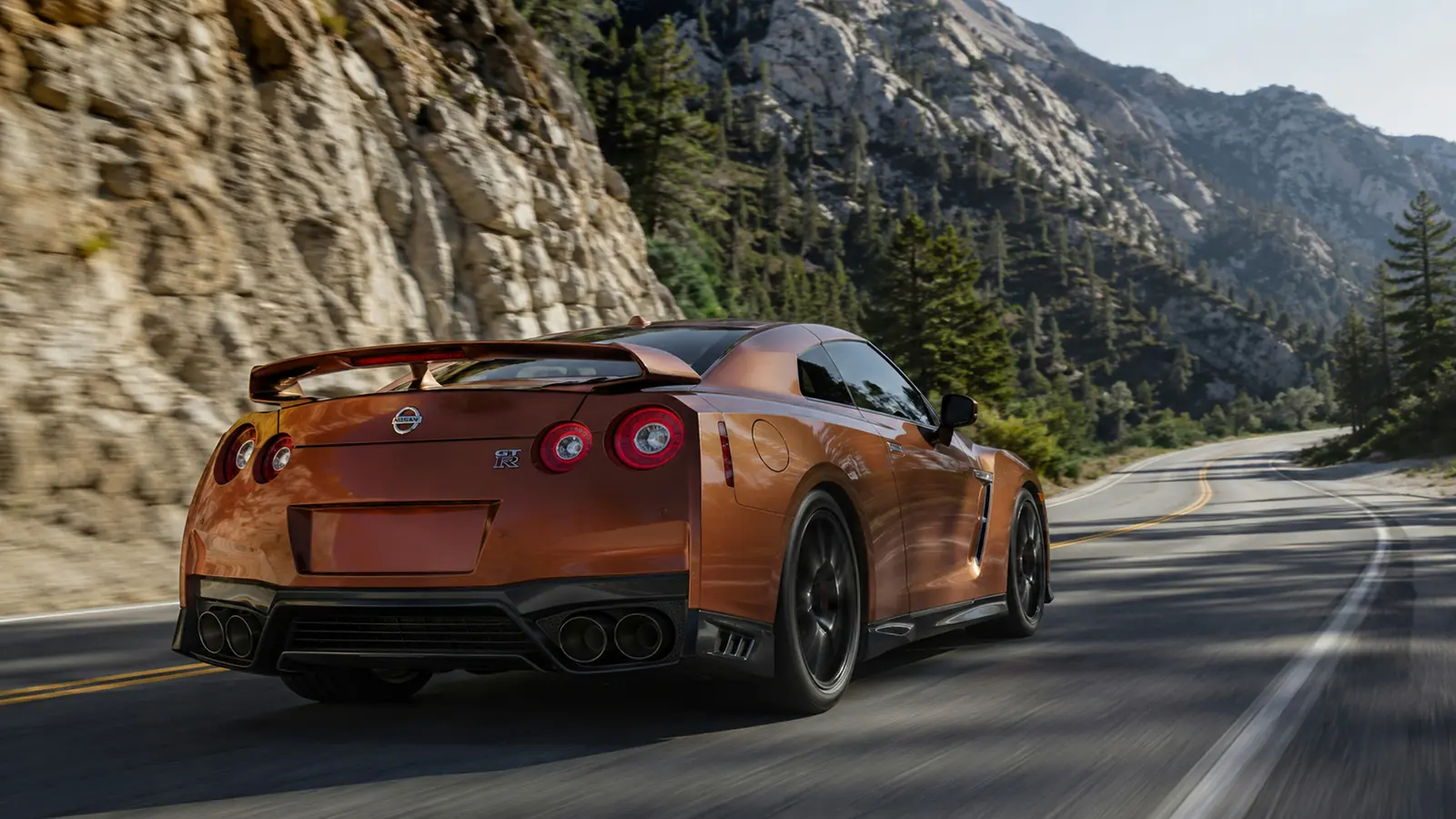 АВТО 1002588 бронзовый Nissan GT-R в движении по горному шоссе