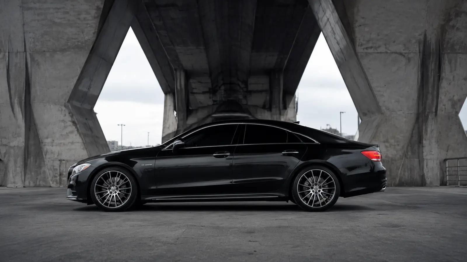 АВТО 1000677 чёрный Mercedes CLS в профиль под архитектурным путепроводом