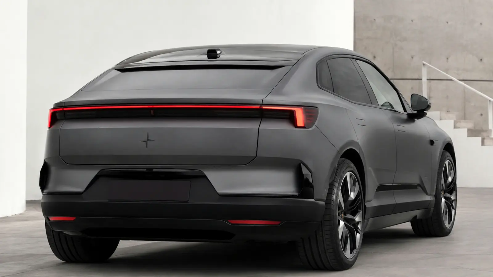 АВТО 1002820 серый Polestar 4 крупно сзади у минималистичной архитектуры