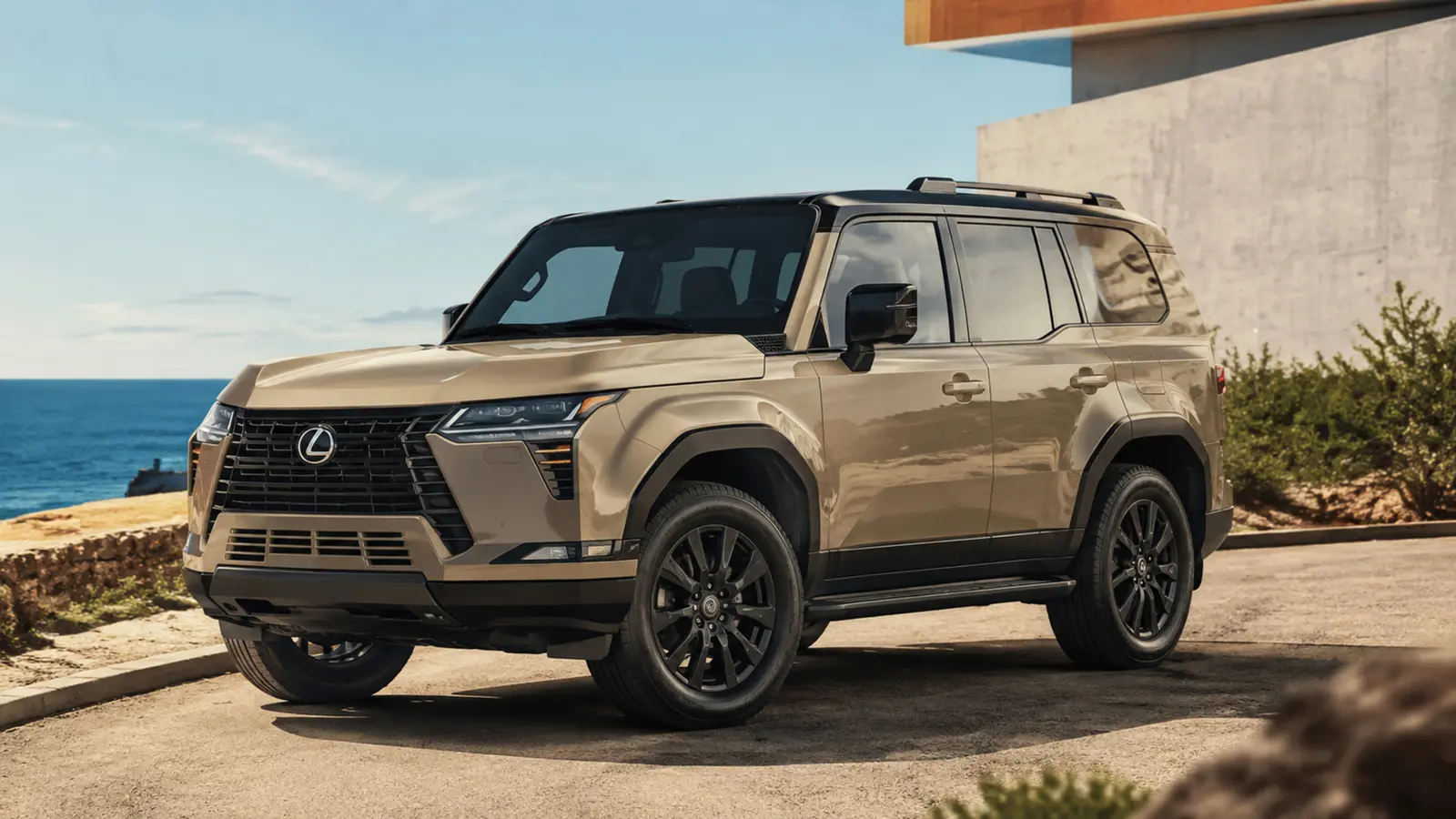 АВТО 1003043 песочный Lexus GX 550 крупно общий ракурс с выразительной архитектурой на сухой приморской дороге