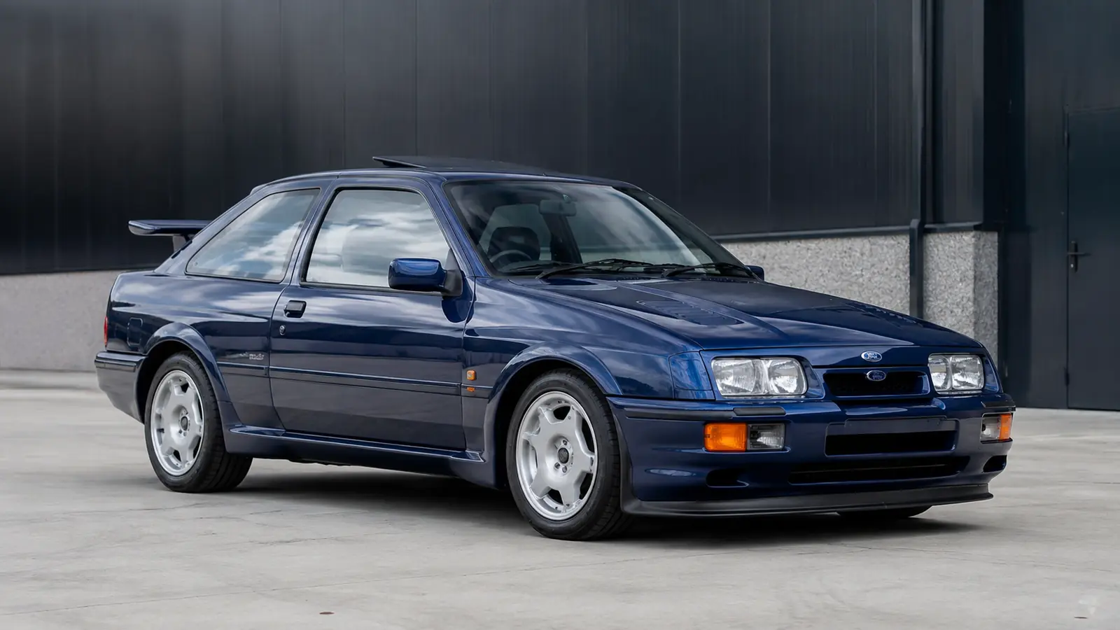 АВТО 1002488 синий Ford Sierra Cosworth рестомод в индустриальном дворе