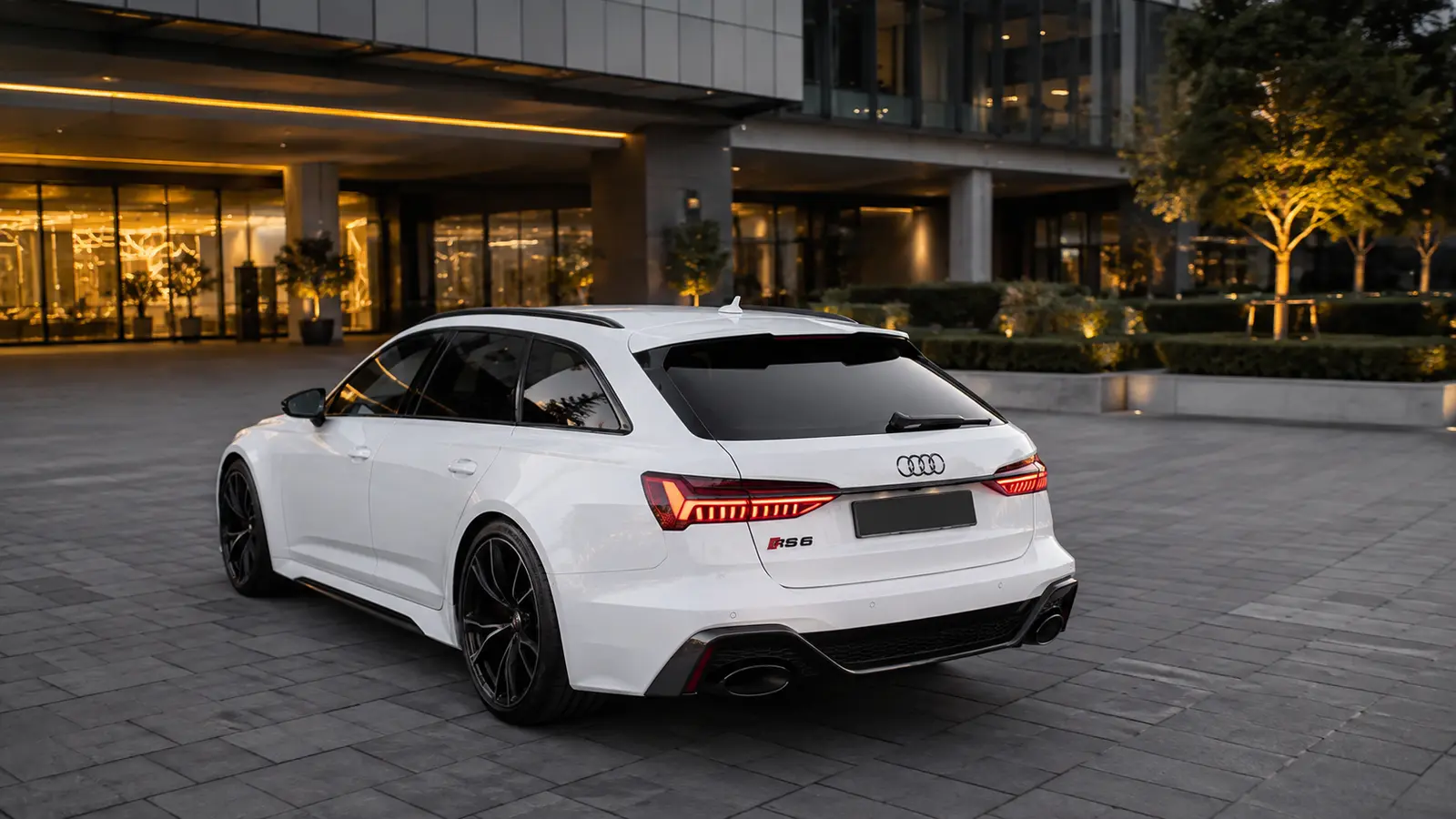 АВТО 1000969 белый Audi RS6 Avant у современного отеля