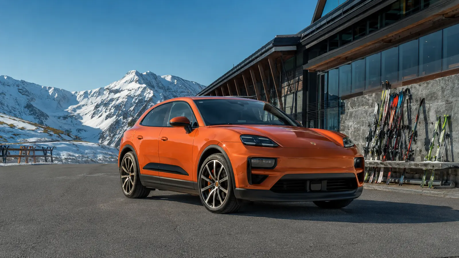АВТО 1001572 Оранжевый Porsche Macan Electric у современной горнолыжной школы