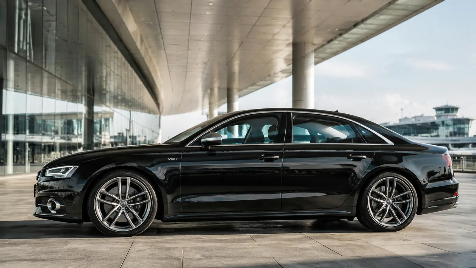 АВТО 1003000 чёрный Audi S8 крупный боковой профиль у нового аэропортового терминала