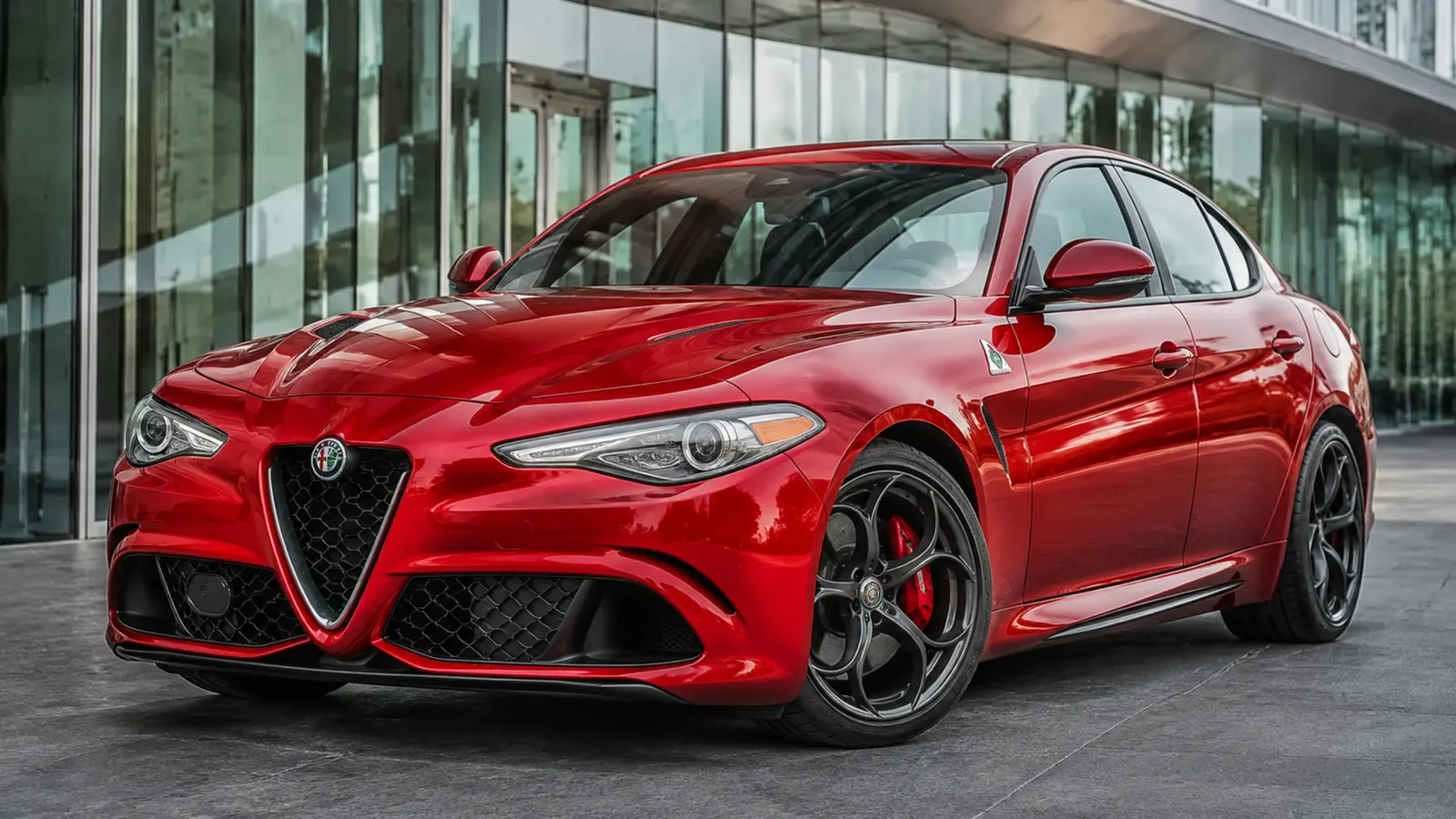 АВТО 1002981 красный Alfa Romeo Giulia Quadrifoglio очень крупно передний боковой ракурс у стеклянной архитектуры