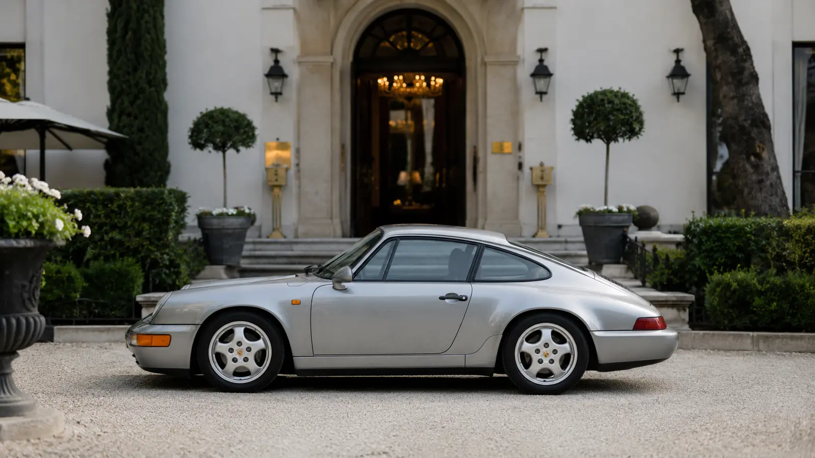 АВТО 1000985 серебристый Porsche 964 у европейского отеля 90-х
