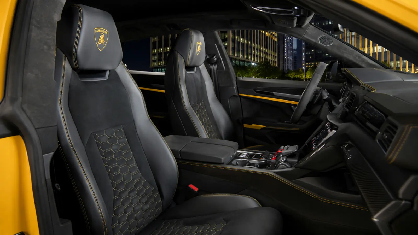 АВТО 1003034 жёлтый Lamborghini Urus Performante передние кресла и центральная консоль крупным планом в вечернем бизнес-квартале