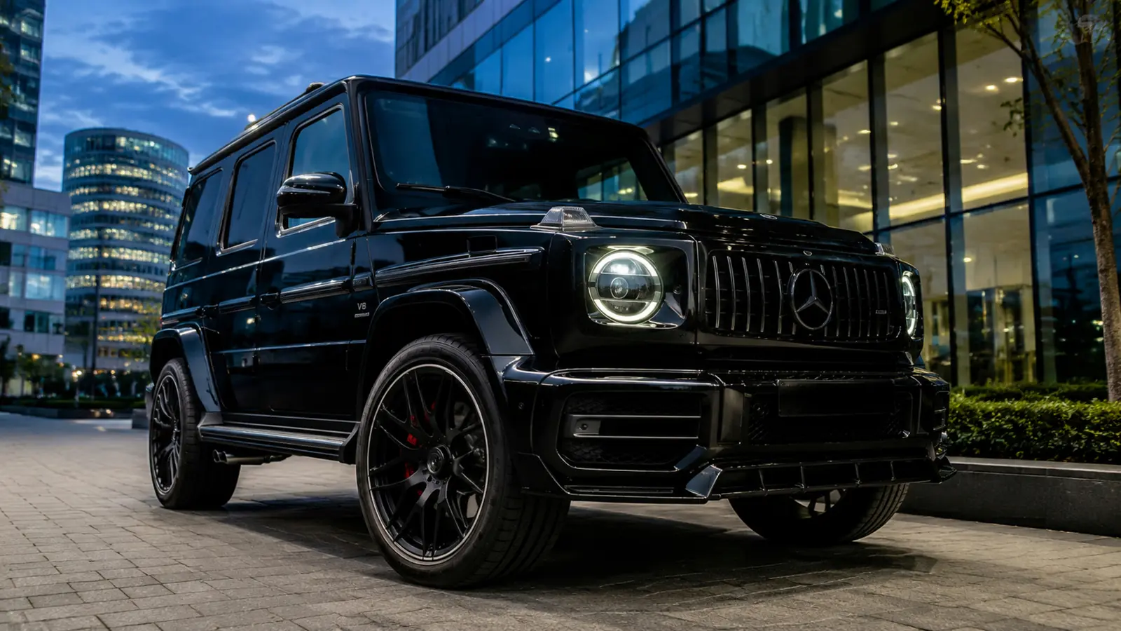 АВТО 1002907 чёрный прокаченный Mercedes G 63 крупно в вечернем деловом квартале