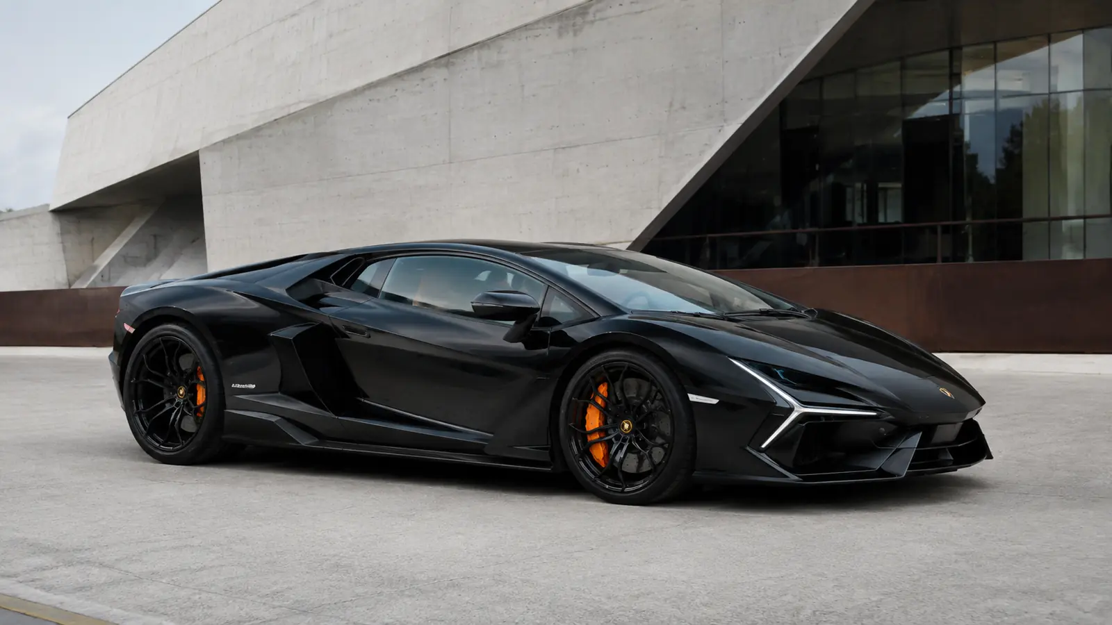 АВТО 1002776 чёрный Lamborghini Revuelto крупно у бетонного музея