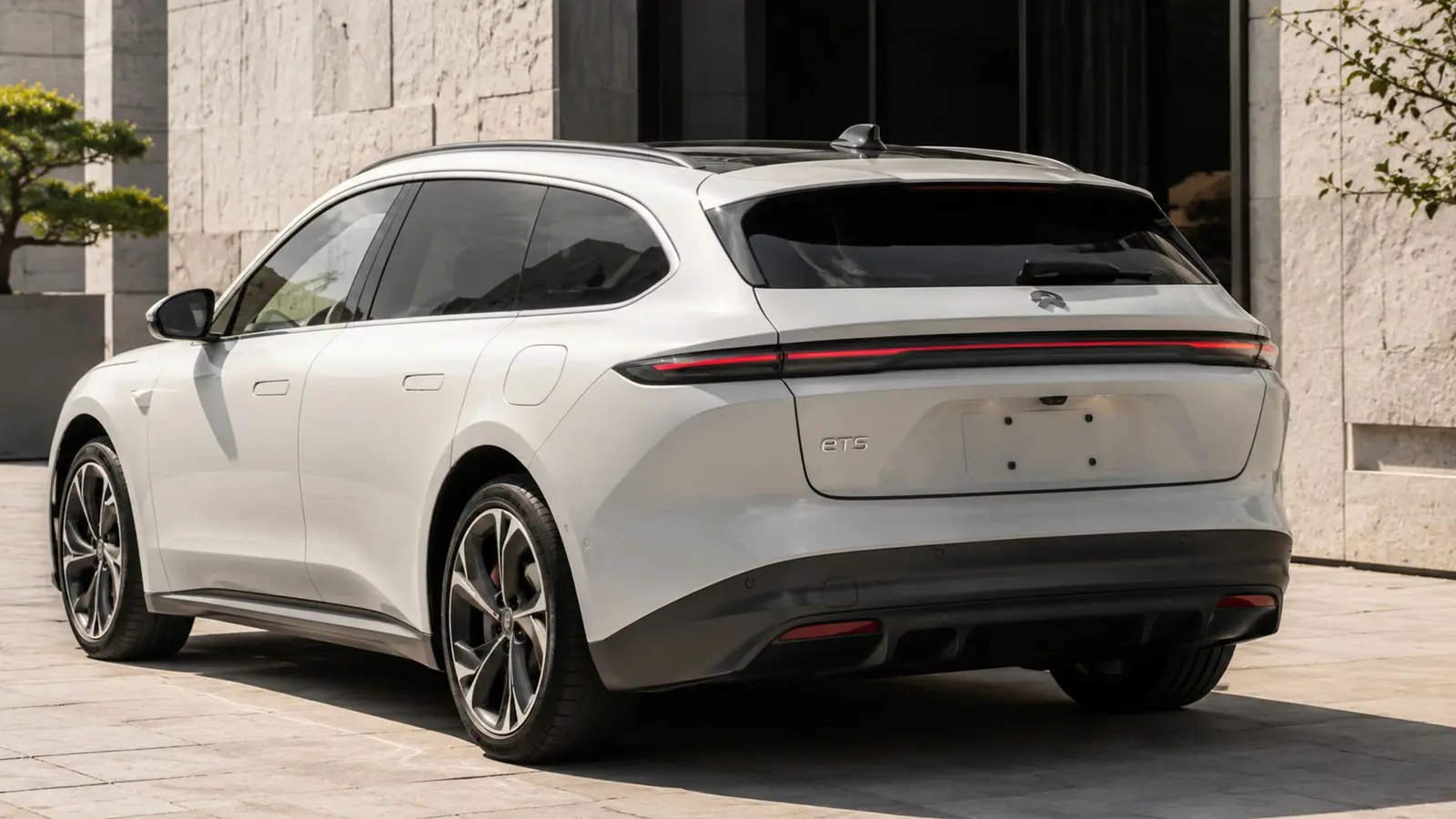 АВТО 1002800 белый Nio ET5 Touring крупно у светлого каменного двора
