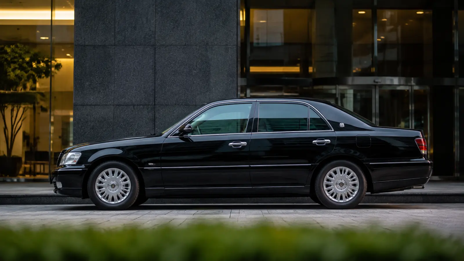 АВТО 1000947 чёрный Toyota Crown у токийского офиса 2000-х