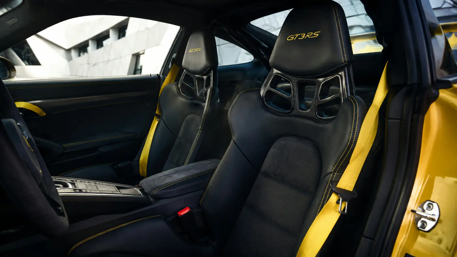 АВТО 1002998 жёлтый Porsche 911 GT3 RS передние кресла и центральная консоль крупным планом у геометричного фасада