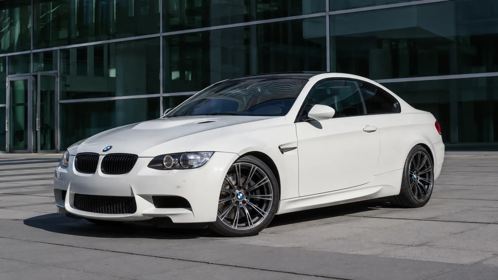 АВТО 1000479 белая BMW M3 E92 у современного здания