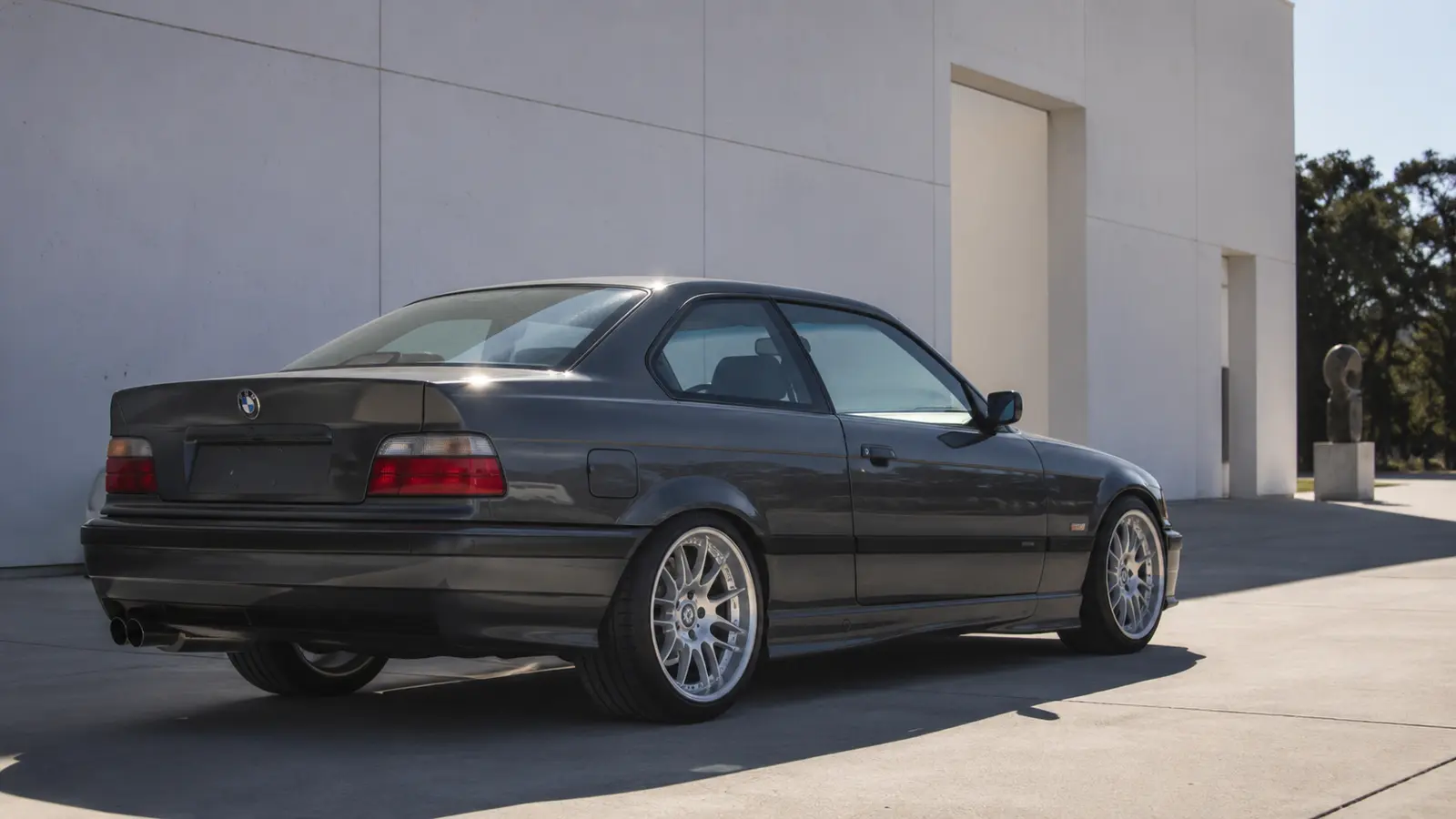 АВТО 1002178 серый BMW E36 рестомод крупно у современной галереи