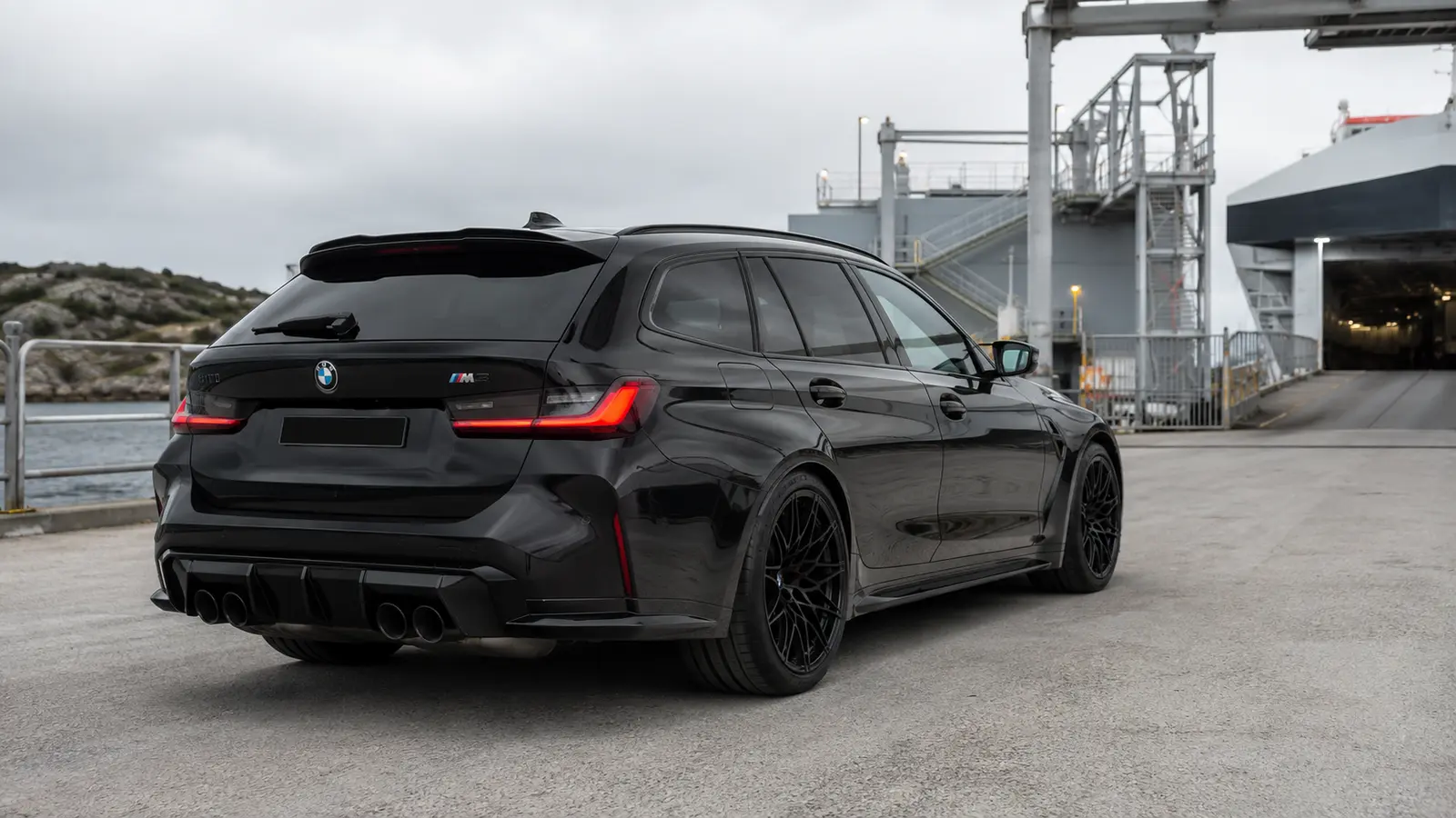 АВТО 1001573 Чёрный BMW M3 Touring у современного морского терминала