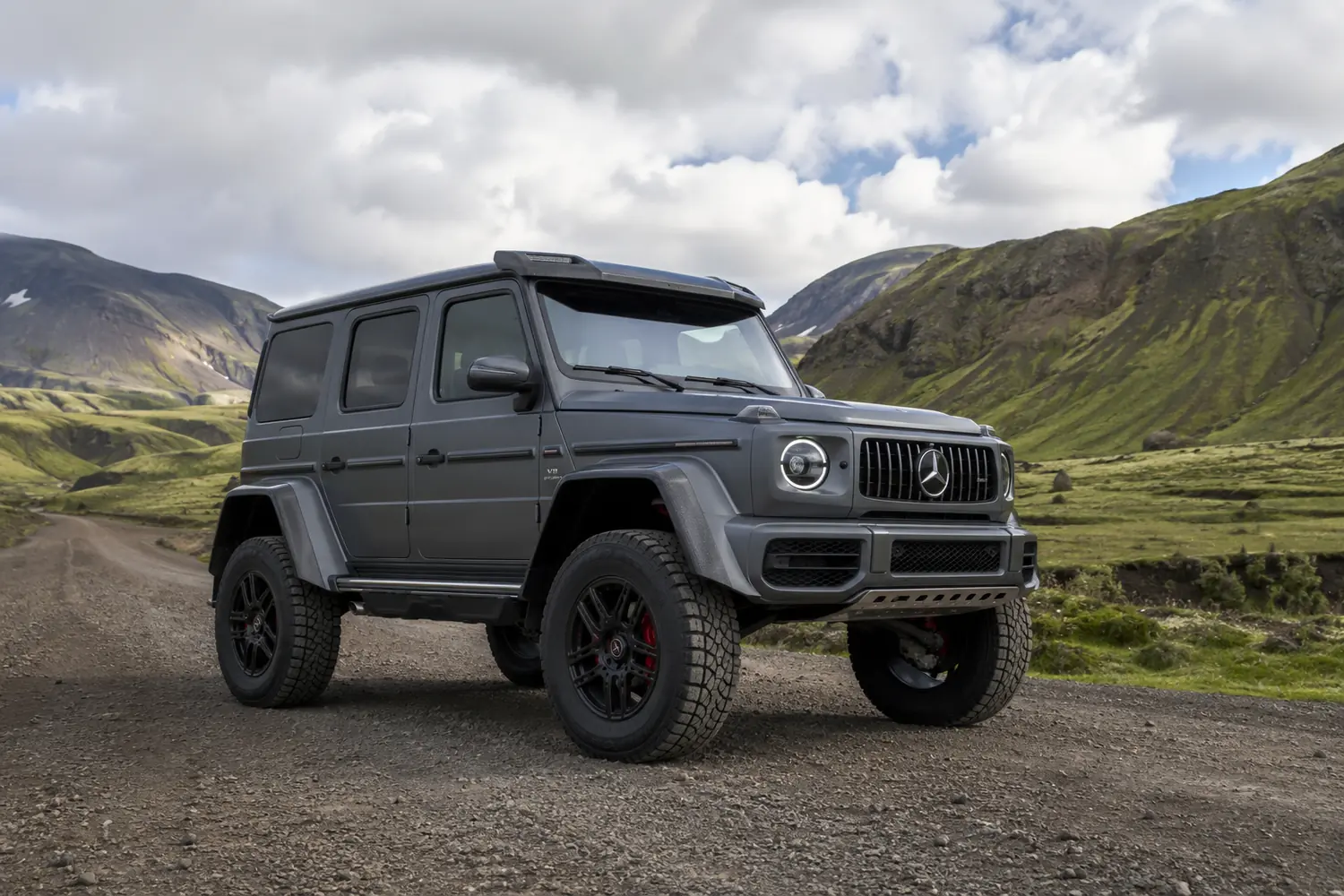 АВТО 1003824 серый Mercedes G63 4x4 на горной гравийной дороге