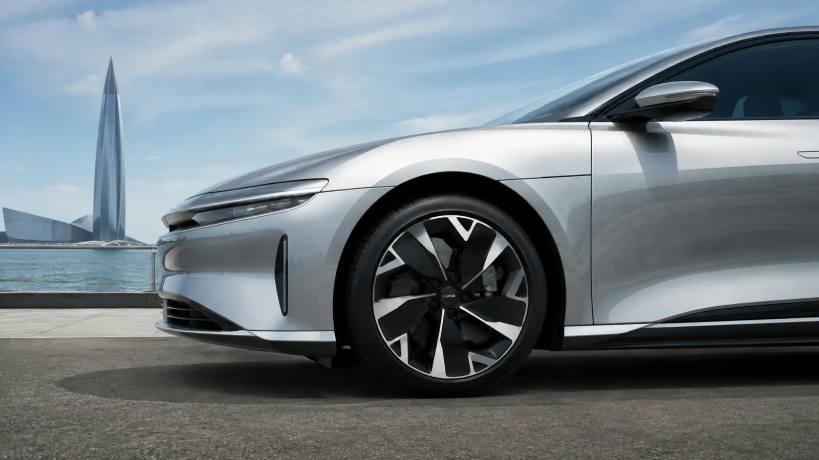 АВТО 1002987 серебристый Lucid Air диск и переднее крыло крупным планом у Лахта Центра