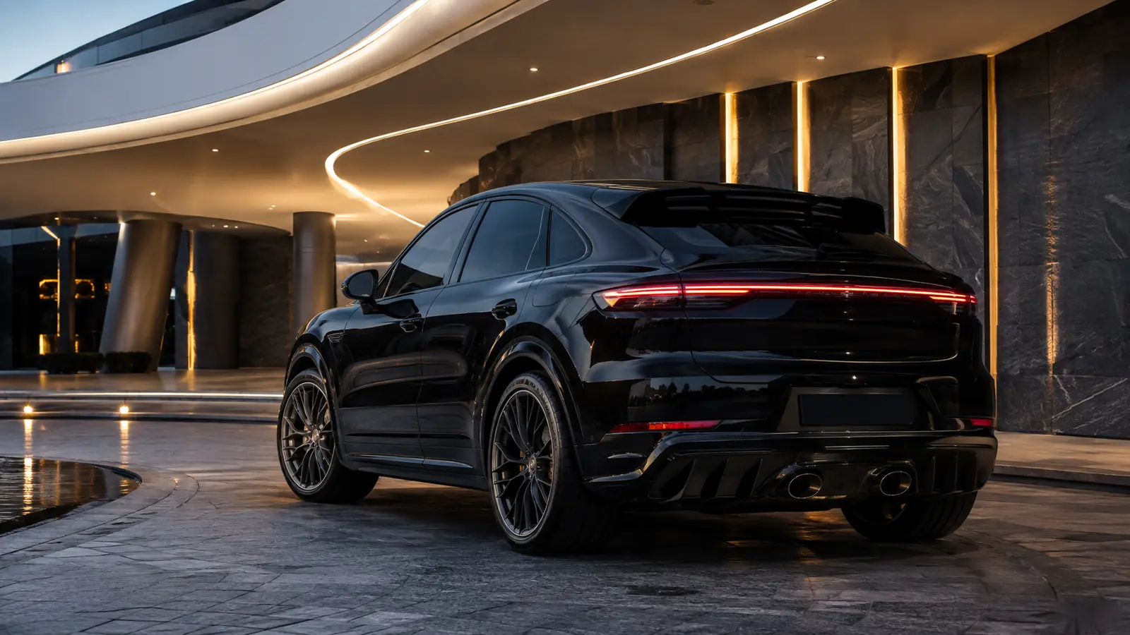 АВТО 1002014 чёрный Porsche Cayenne Turbo GT у футуристичного отеля