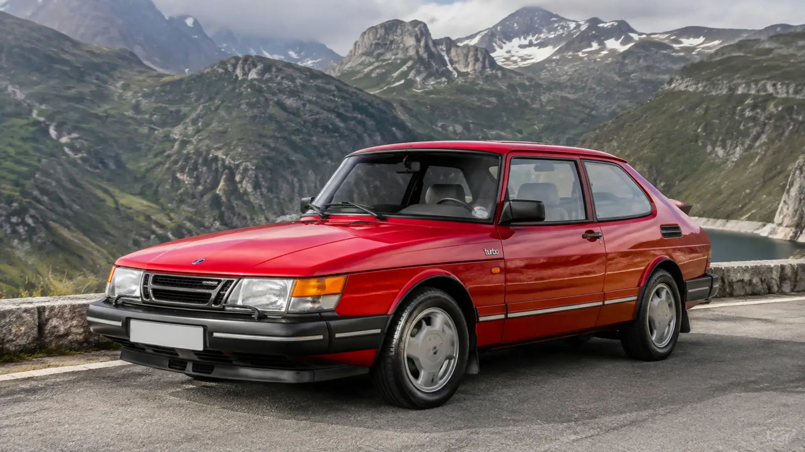 АВТО 1003066 красный Saab 900 Turbo крупно общий ракурс с выразительной архитектурой на горном перевале