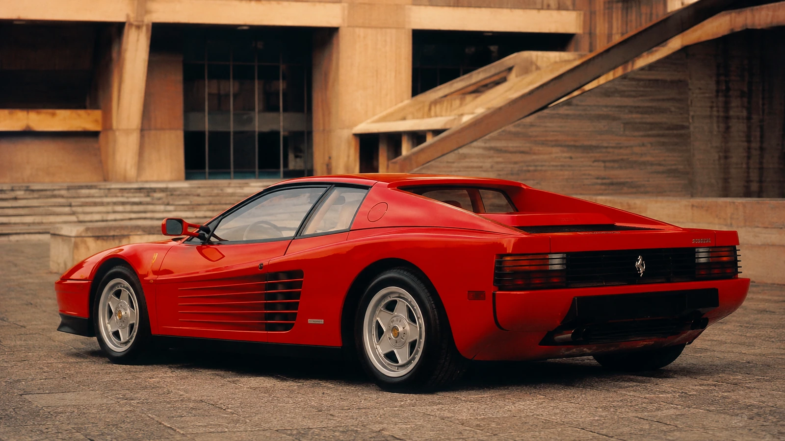 АВТО 1000714 красная Ferrari Testarossa у бруталистской архитектуры 80-х