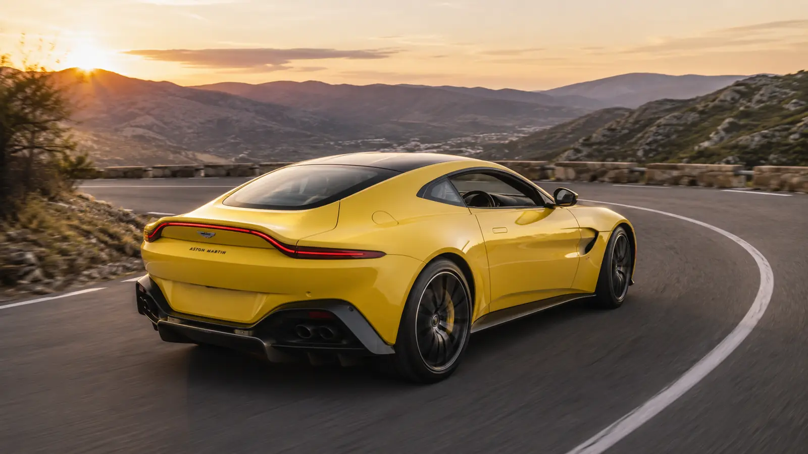 АВТО 1002434 жёлтый Aston Martin Vantage в движении по серпантину