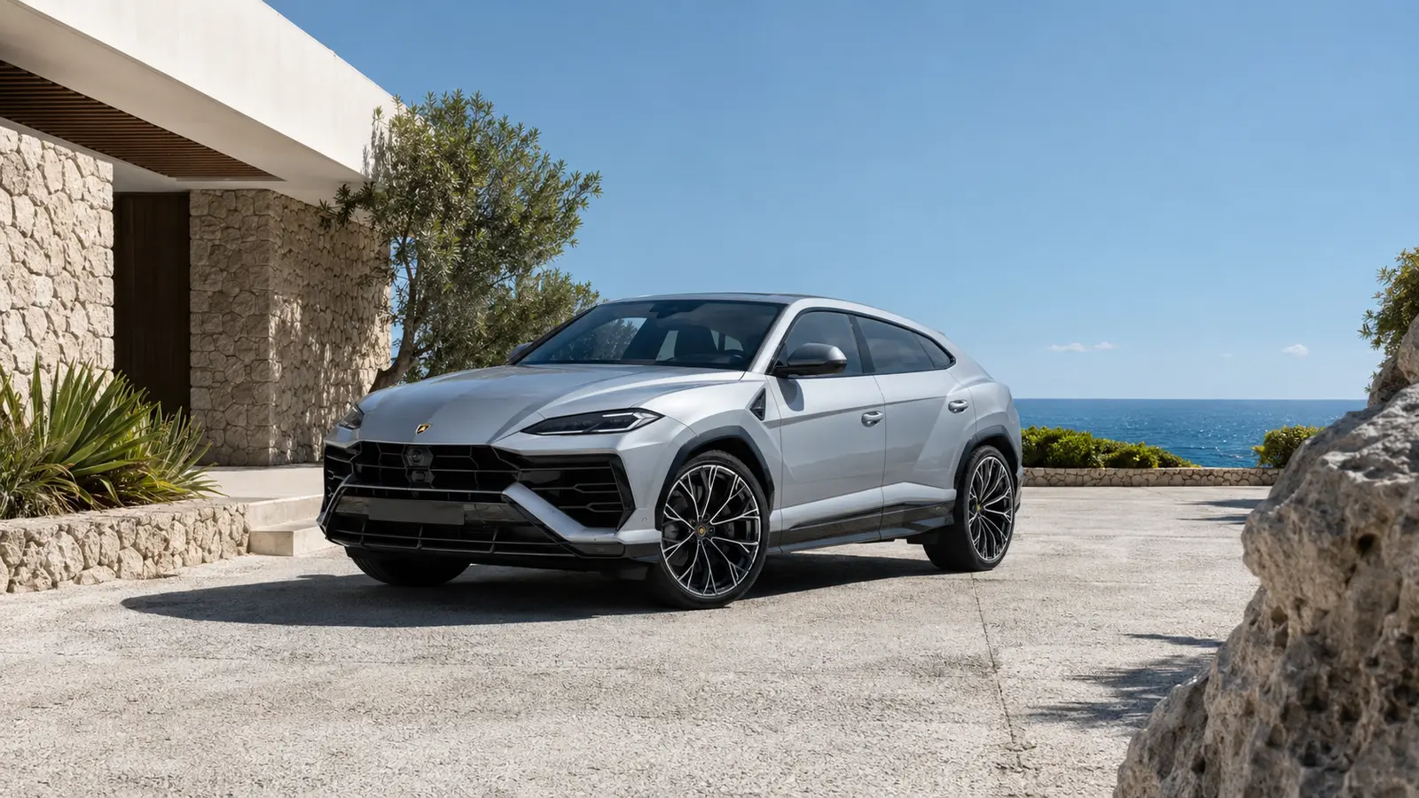 АВТО 1001599 Серебристый Lamborghini Urus SE у скалистой приморской виллы