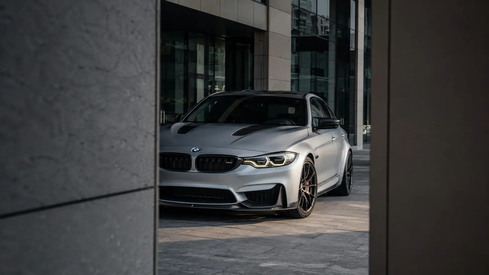 АВТО 1003242 серебристый BMW M3 CS крупно через архитектурный проём